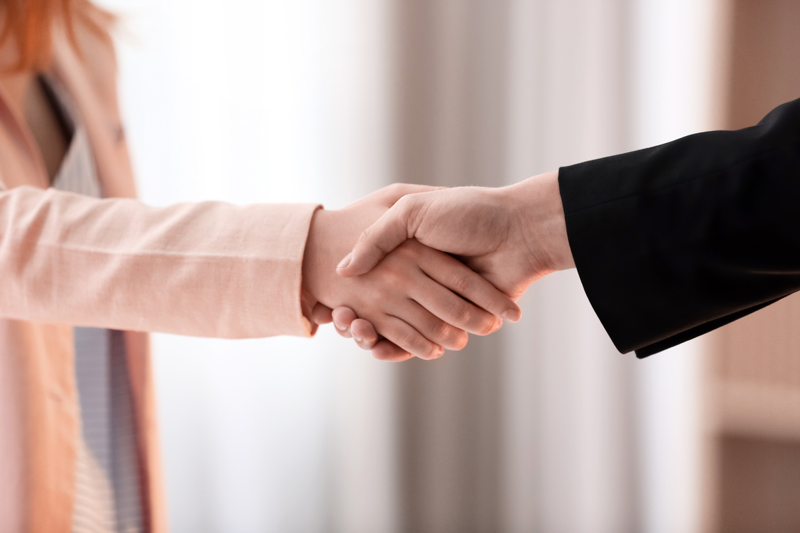 Man and Woman Shaking Hands With a Blurred Background